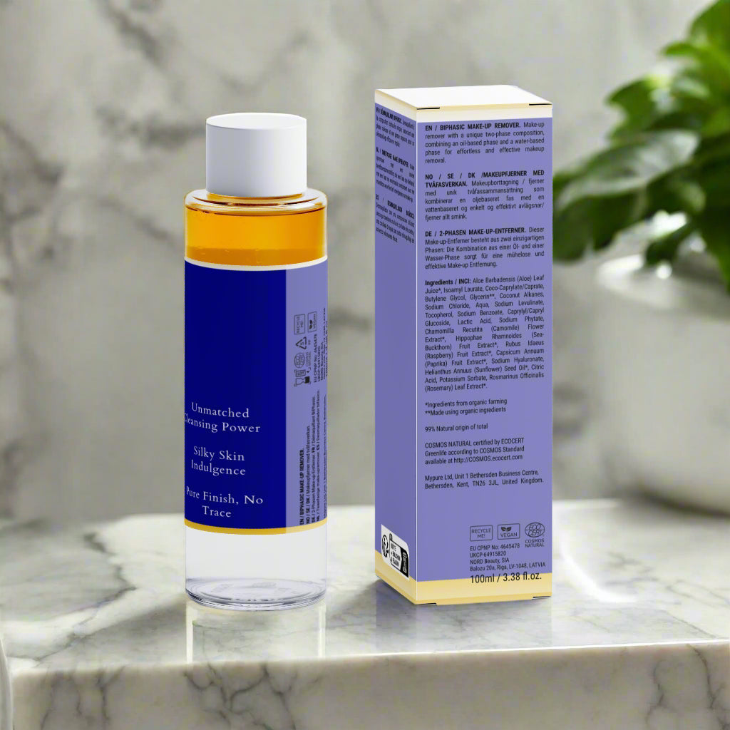 Bottle and box of a skincare product on a marble surface with a plant in the background