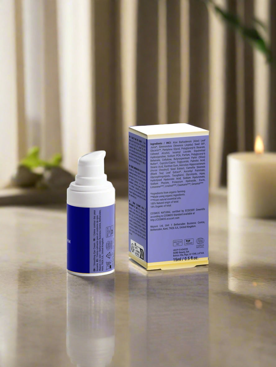 Blue skincare bottle and box on a reflective surface with a blurred background