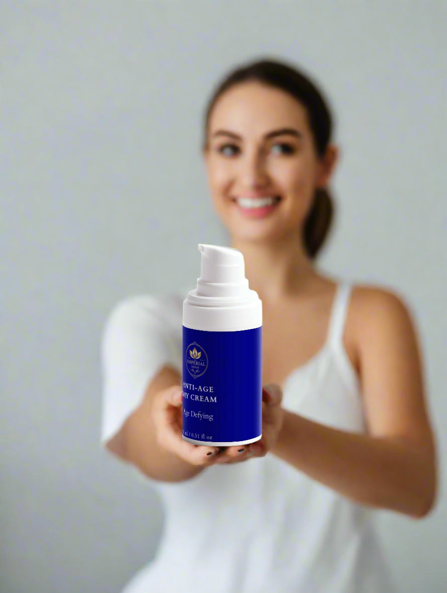 Woman holding a blue skincare product with a gray background