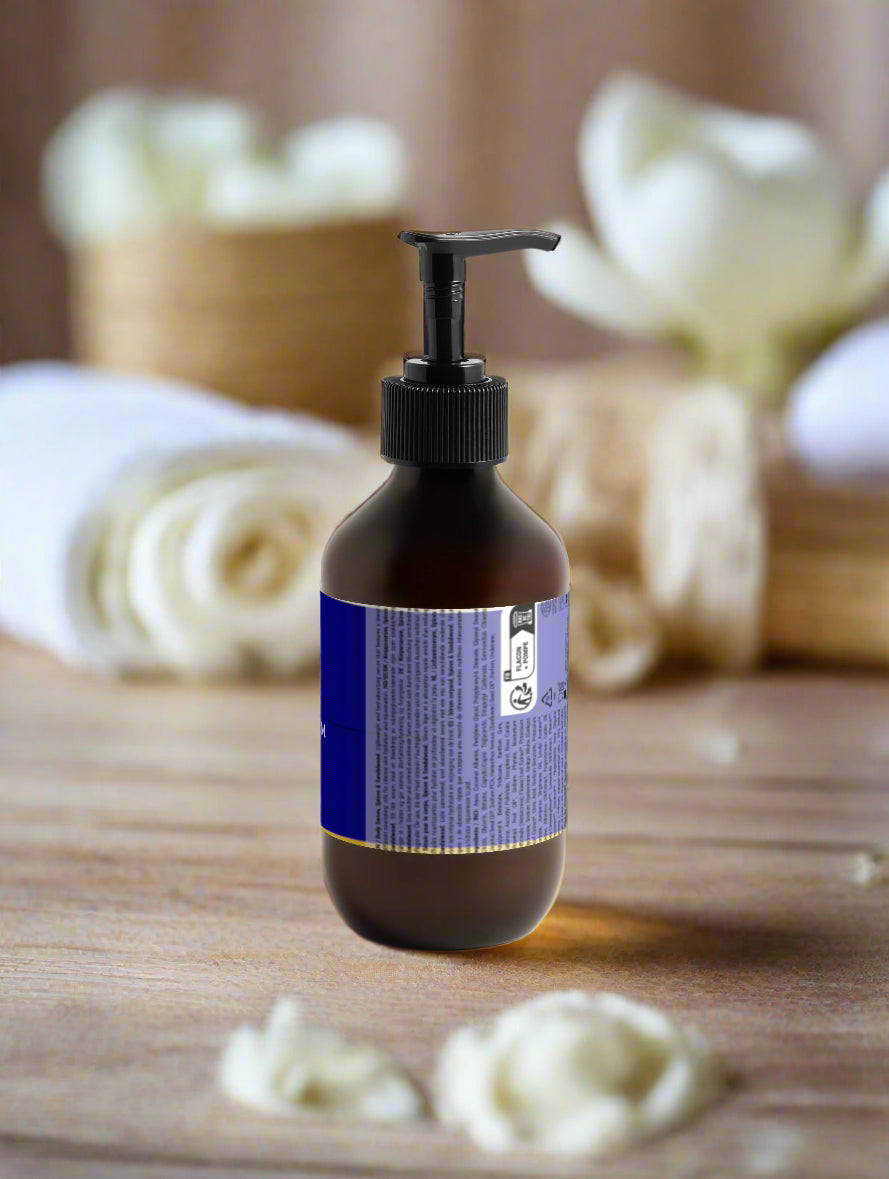 Brown bottle with a purple label on a wooden surface with loofahs in the background