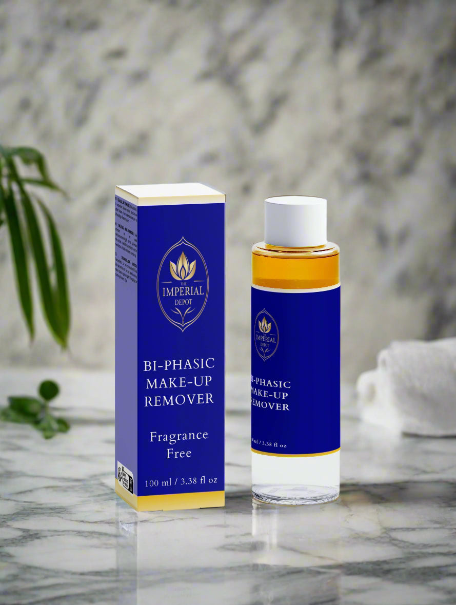 Bi-phasic makeup remover bottle and packaging on a marble surface with a plant in the background